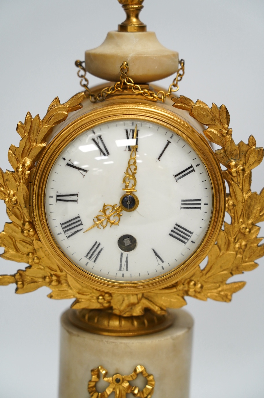 A late 19th century French alabaster and gilt metal timepiece with enamel dial, with key, 31cm high. Condition - fair